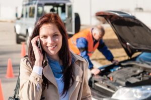 Woman talking on cellphone after car breakdown